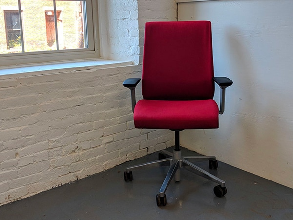 A red remanufactured Steelcase Think Chair.